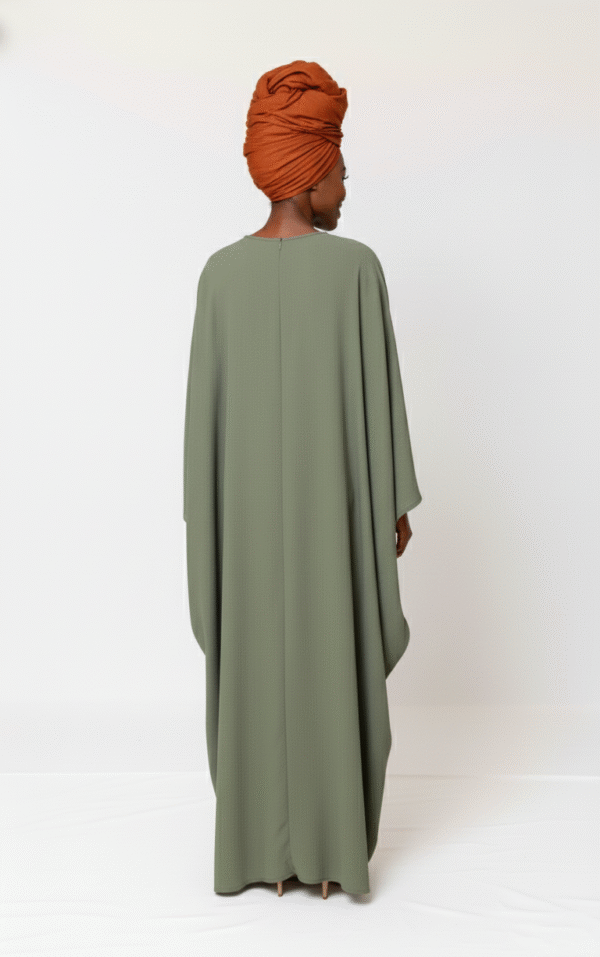Women’s modest green abaya with flowing fabric and orange turban, perfect for stylish modest fashion.