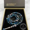 Blue and gray beaded jewelry set with a silver charm, handcrafted in Canada, displayed in a Umeed De.