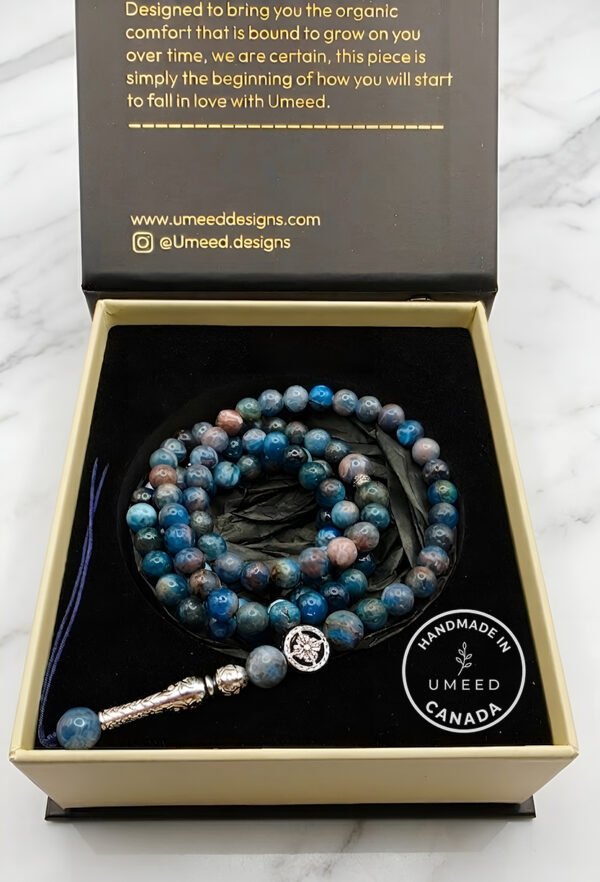 Blue and gray beaded jewelry set with a silver charm, handcrafted in Canada, displayed in a Umeed De.