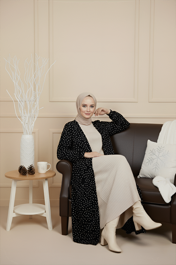 Modest fashion woman wearing beige and black polka dot outfit with cream boots.