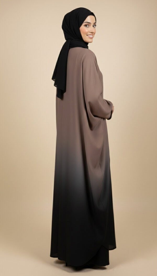 Woman wearing a stylish gradient abaya with black hijab, full-length modest fashion.