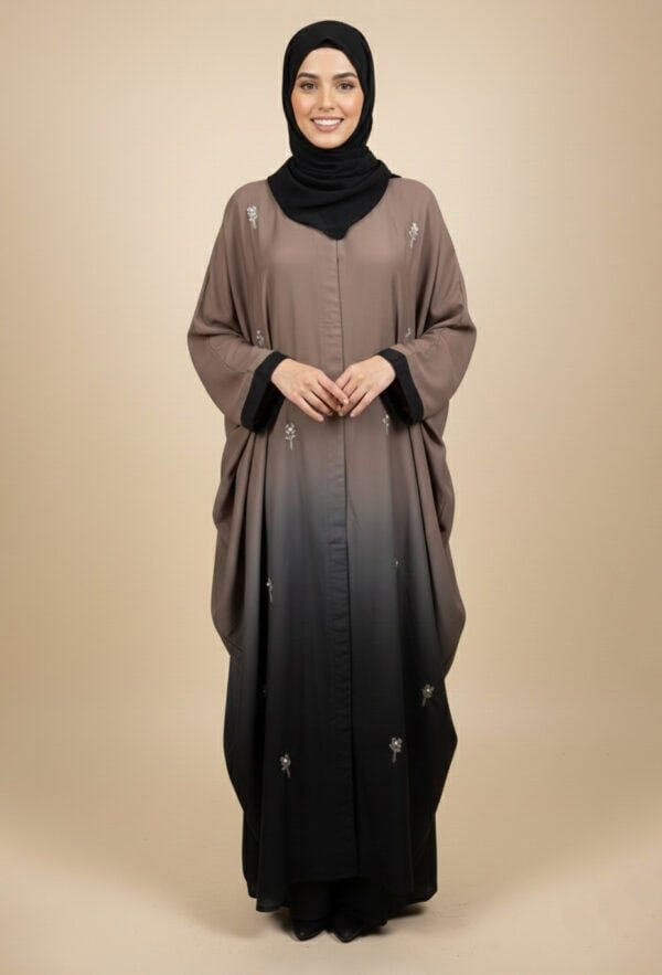 Woman wearing a stylish, embellished abaya with a black hijab, standing confidently.