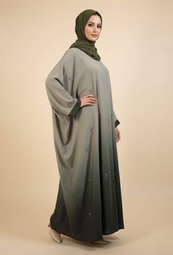 Woman wearing a stylish, modest abaya with embroidery and a green hijab.