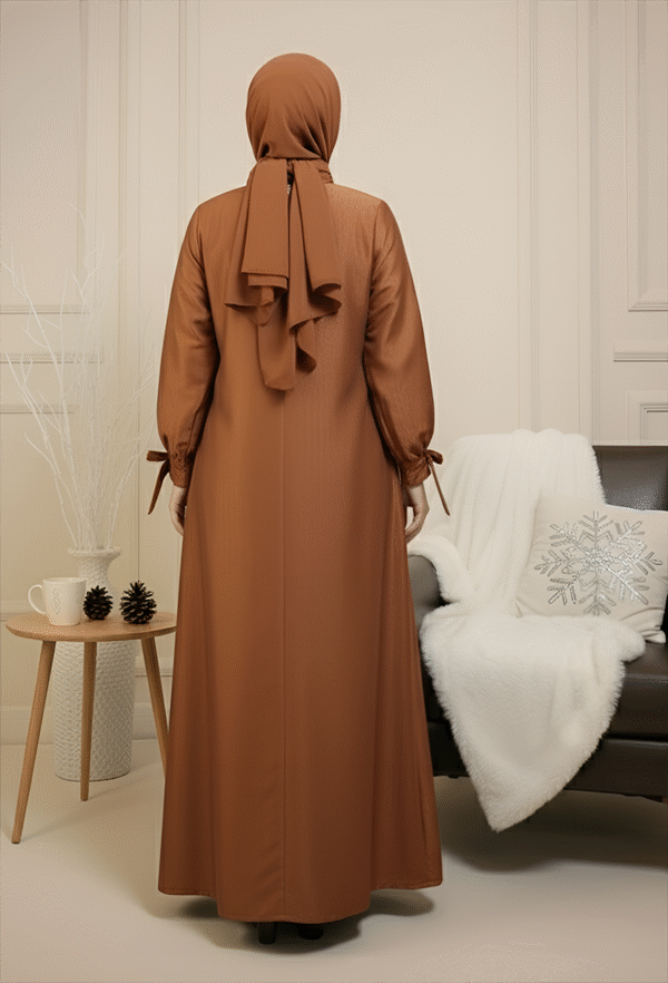 Modest women's dress with long sleeves, tied cuffs, and a matching headscarf, suitable for elegant or traditional wear.