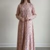Woman wearing a floral maxi dress with long sleeves and a V-neckline.