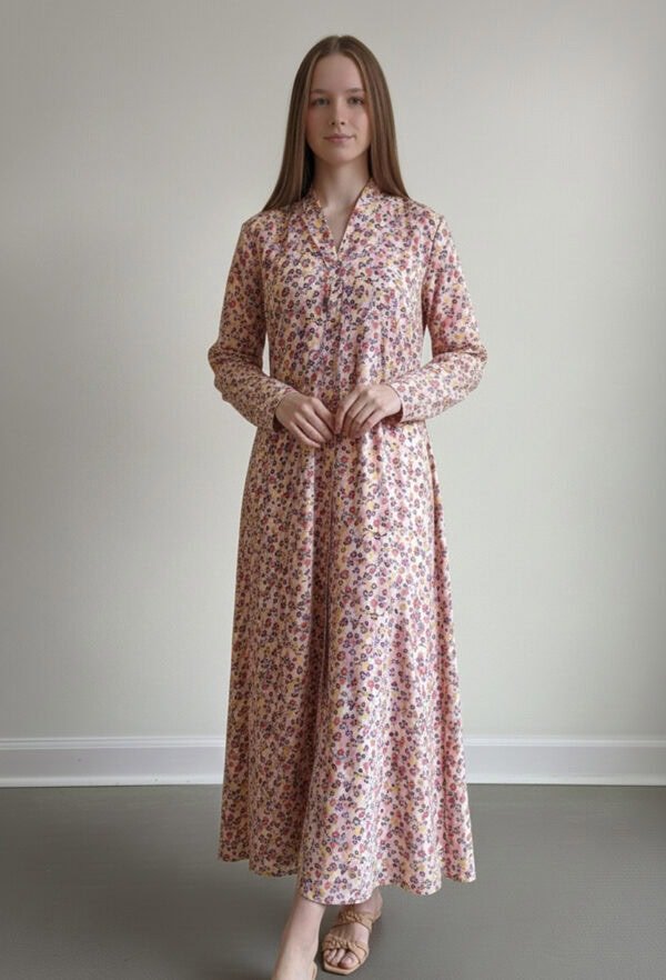 Woman wearing a floral maxi dress with long sleeves and a V-neckline.