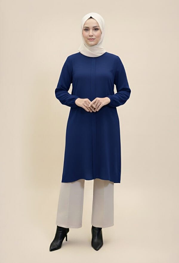 Woman wearing a stylish navy blue modest dress with beige wide-leg pants and black boots.