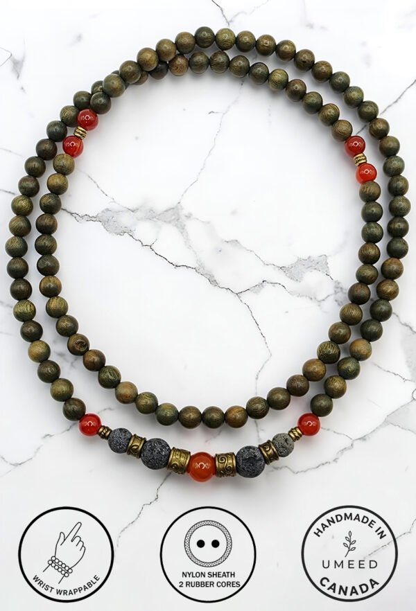 Handmade beaded necklace with red and black beads on a white marble background.