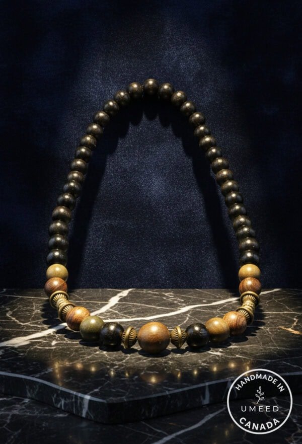 Elegant wooden beaded necklace with mixed natural tones and brass accents. Perfect for boho or casua.