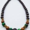 Stylish beaded necklace featuring black, green, and wooden beads with gold accents. Perfect for casu.