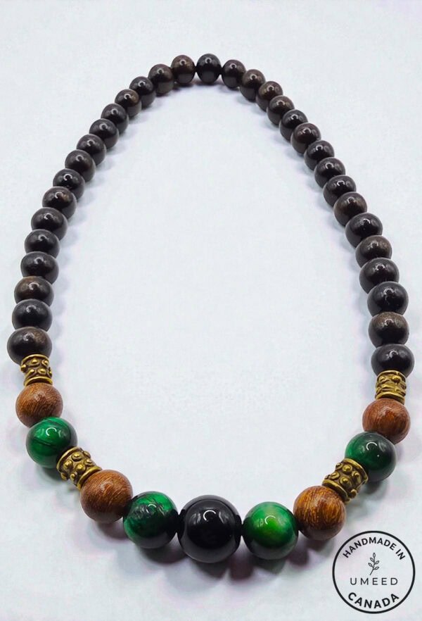 Stylish beaded necklace featuring black, green, and wooden beads with gold accents. Perfect for casu.