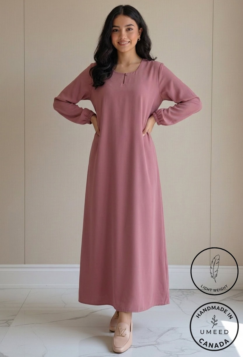 Elegant pink maxi dress with long sleeves and a relaxed fit, perfect for casual or formal occasions.