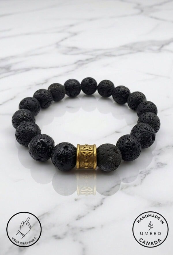 Black lava stone bracelet with gold accent bead, handmade jewelry.