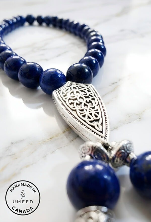Blue beaded necklace featuring a detailed silver pendant, handcrafted jewelry from Umeed Designs in.