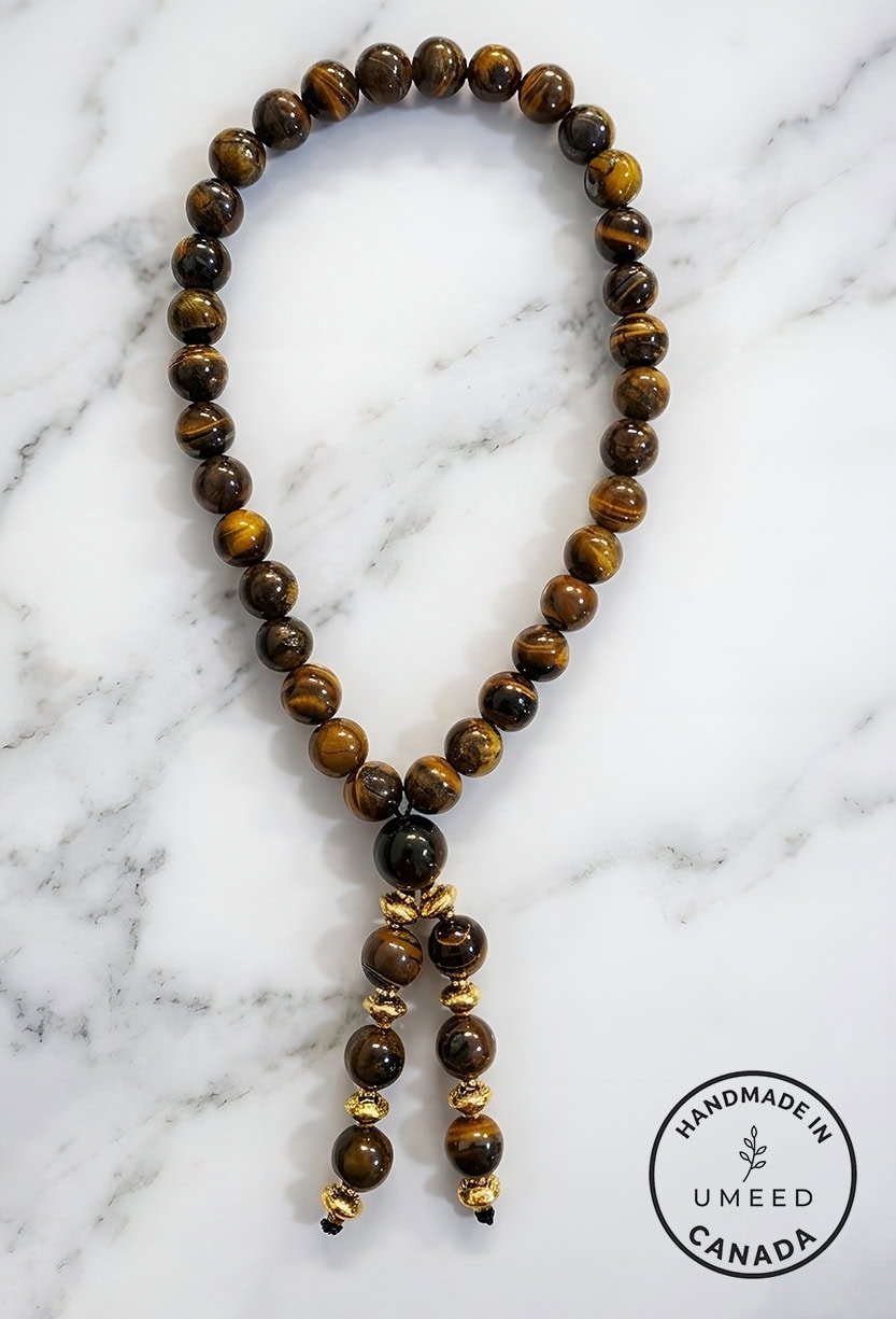 Beaded wooden necklace with gold accents on marble background.