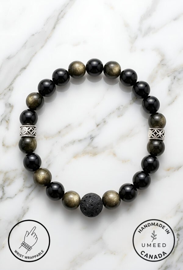 Black and gold beaded bracelet with a lava stone centerpiece on a white marble background.