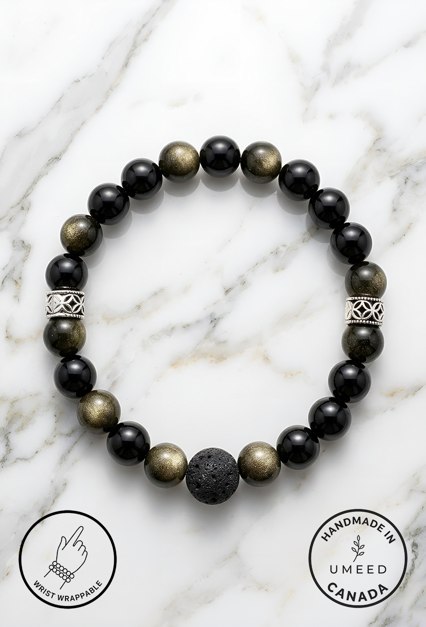 Black and gold beaded bracelet with a lava stone centerpiece on a white marble background.