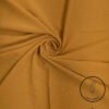 Light weight mustard yellow fabric with subtle glitter and feather logo.