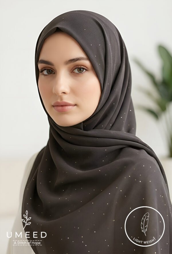 Elegant woman wearing a dark grey hijab with subtle sparkles.