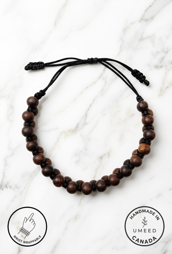Handmade wooden bead bracelet with adjustable cord on marble background.