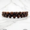 Handmade wooden bead bracelet from Umeed Designs on a marble surface.
