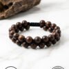 Handmade wooden bead bracelet from Umeed Designs on a marble surface.