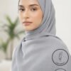 Elegant woman wearing a light gray hijab with a soft background.