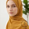 Elegant woman wearing a mustard yellow hijab with a light weight and non-slip design.