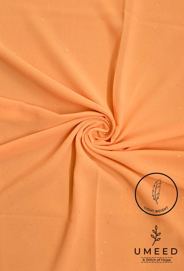 Peach-colored fabric with subtle glitter and light weight label from Umeed Designs.