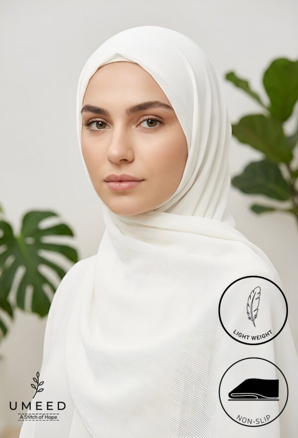 Elegant woman wearing a white hijab with green plant background.